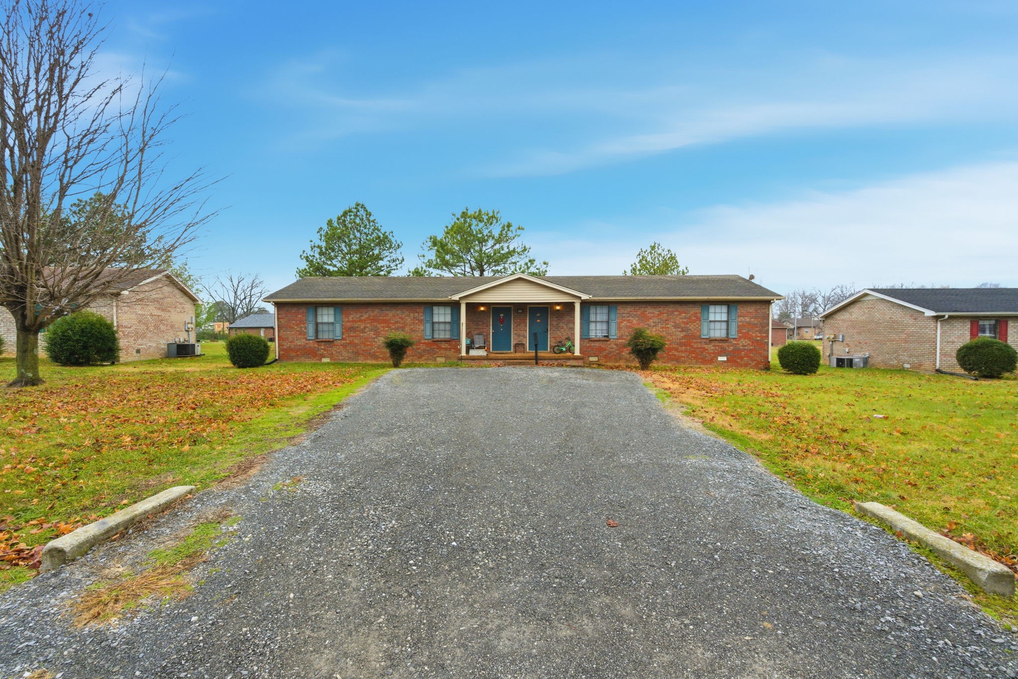a front view of house with yard and trees in the background