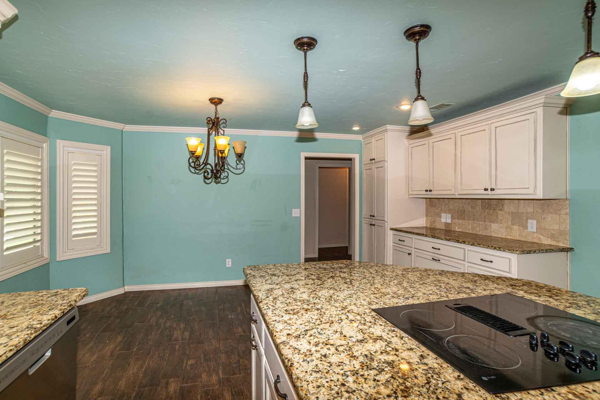 3312 77th Street Lubbock, TX 79423 - Photo 11 of 30 a kitchen with stainless steel appliances granite countertop a stove a sink and a refrigerator
