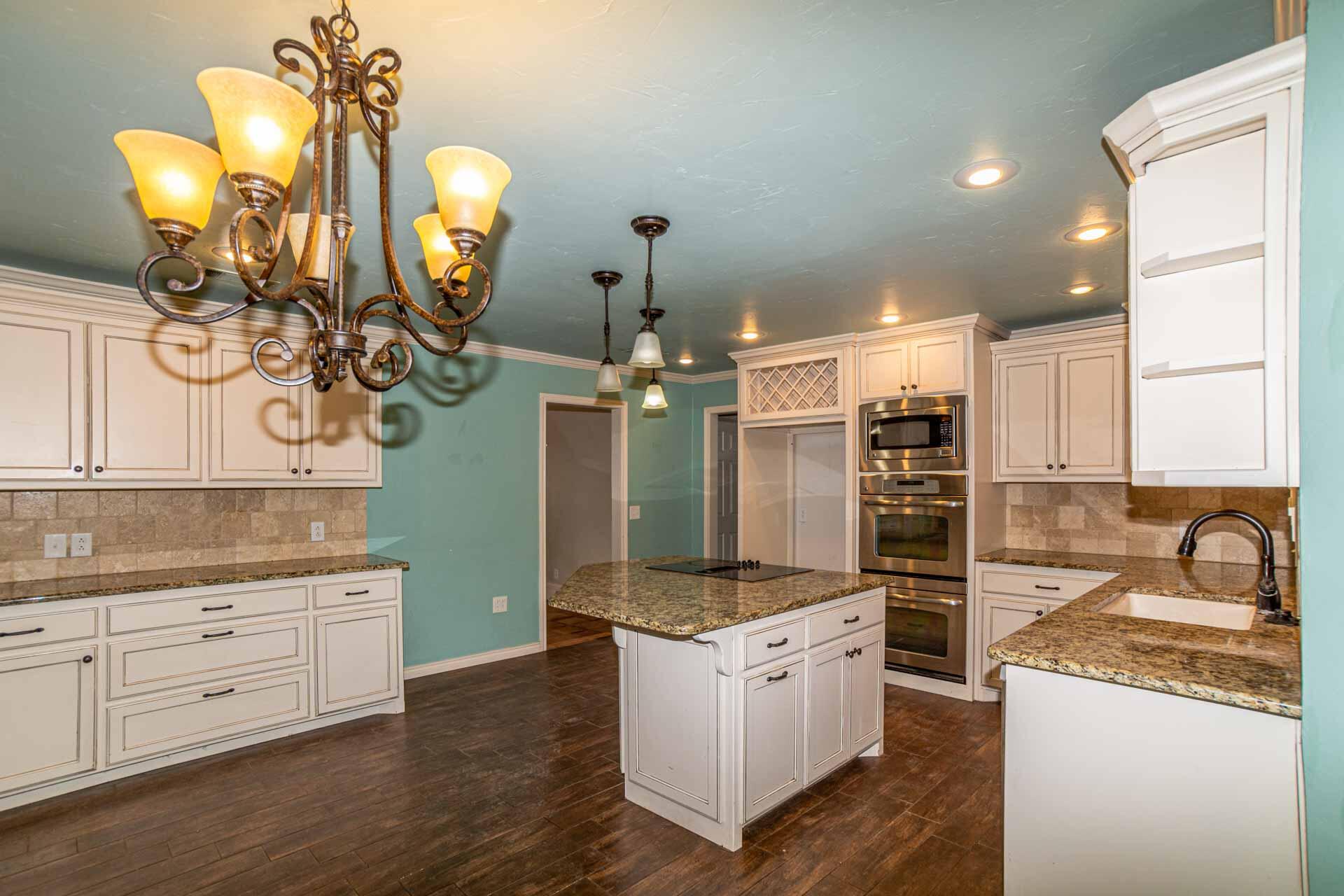 3312 77th Street Lubbock, TX 79423 - Photo 12 of 30 a kitchen with granite countertop a sink a stove and cabinets