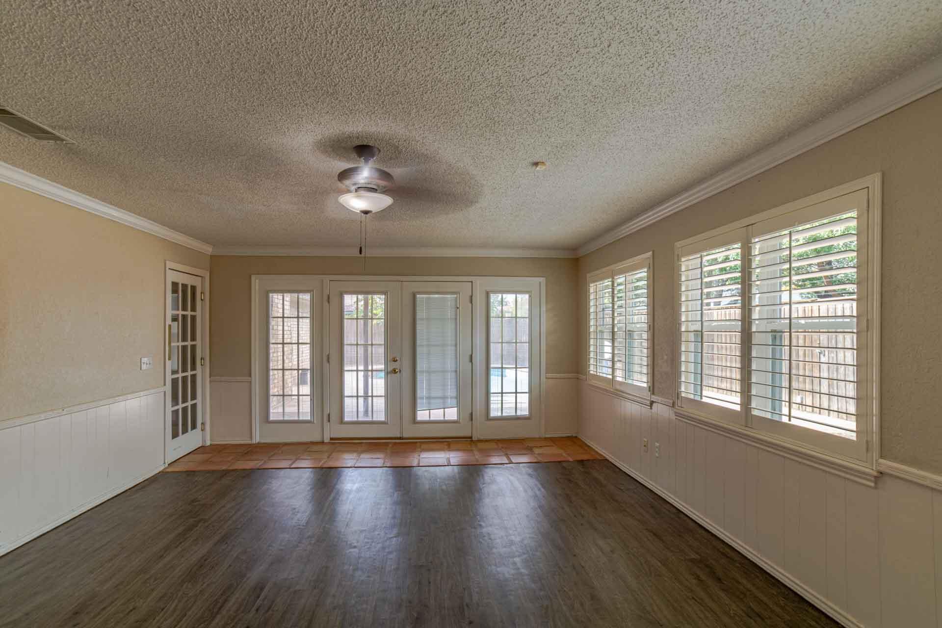 3312 77th Street Lubbock, TX 79423 - Photo 17 of 30 a view of an empty room with wooden floor and a window