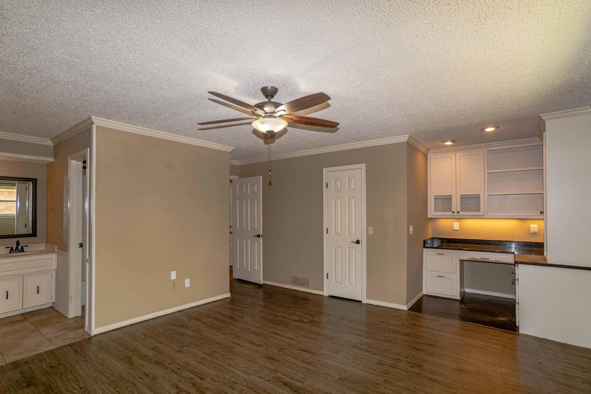 3312 77th Street Lubbock, TX 79423 - Photo 21 of 30 a view of an empty room with wooden floor and a window