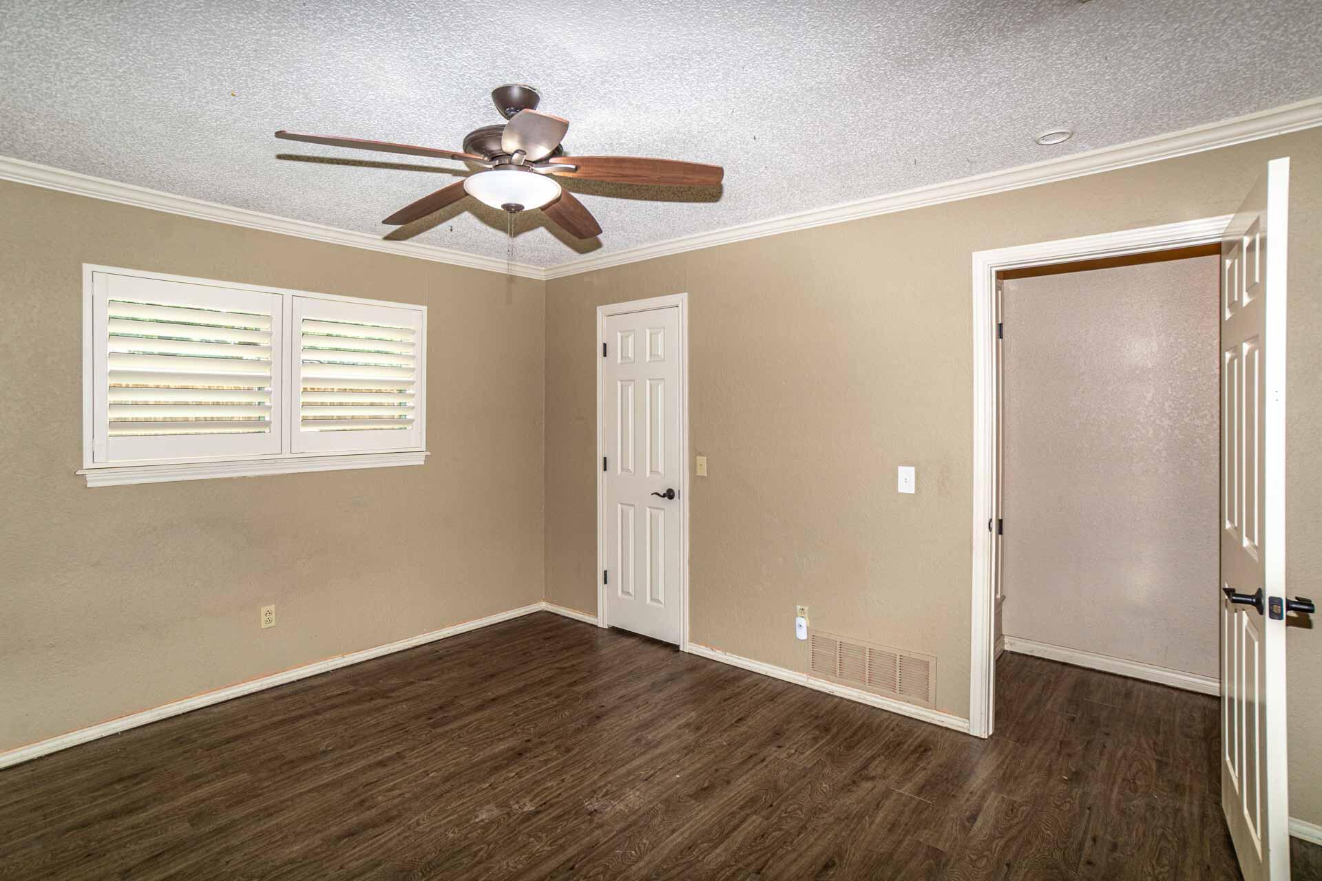 3312 77th Street Lubbock, TX 79423 - Photo 27 of 30 a view of an empty room with wooden floor and a ceiling fan