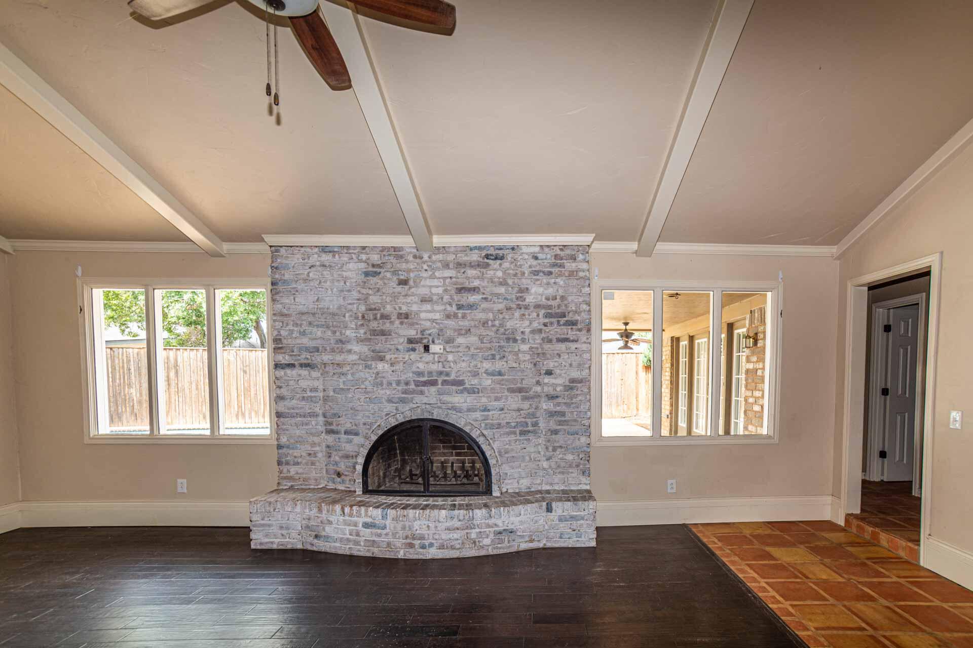 3312 77th Street Lubbock, TX 79423 - Photo 6 of 30 a living room with a fireplace and wooden floor