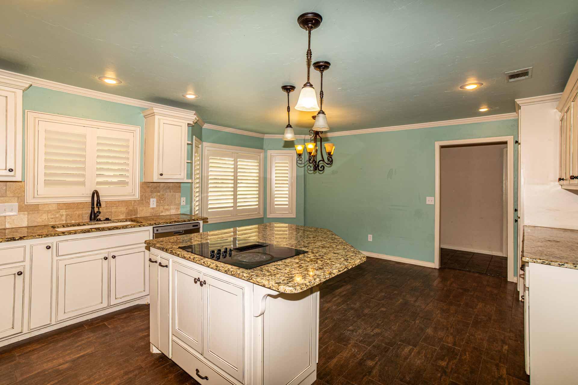 3312 77th Street Lubbock, TX 79423 - Photo 9 of 30 a kitchen with granite countertop a sink and a refrigerator