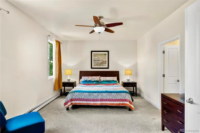 a bedroom with a bed and a lamp on dresser