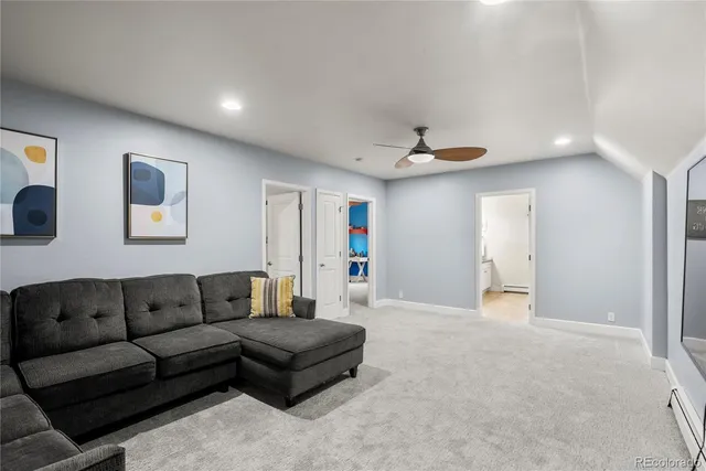 a living room with furniture and a ceiling fan