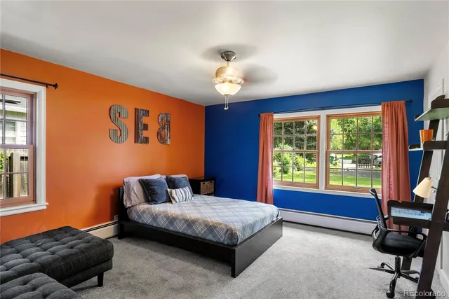 a bedroom with a bed and dresser next to a large window