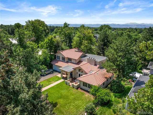 an aerial view of a house with pool big yard and large trees