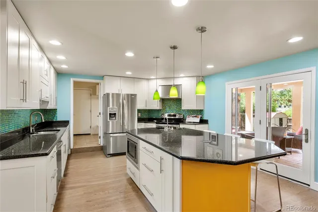 a kitchen with stainless steel appliances granite countertop sink stove and refrigerator