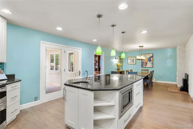 a kitchen with stainless steel appliances granite countertop a sink a stove and a refrigerator