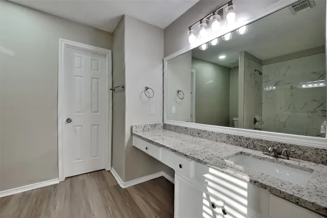 a bathroom with a granite countertop sink and a mirror