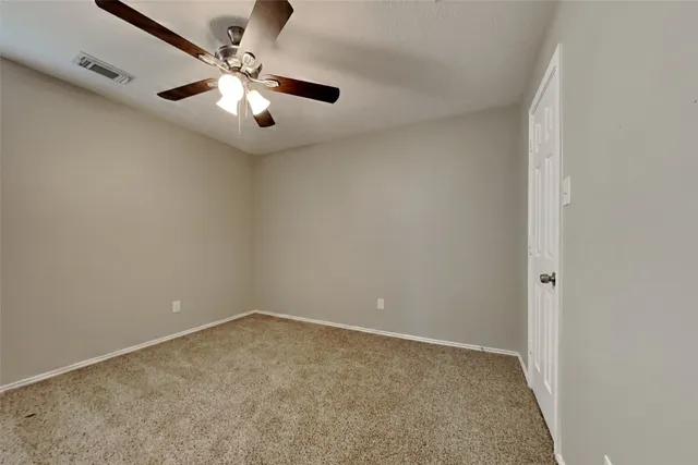 an empty room with chandelier fan