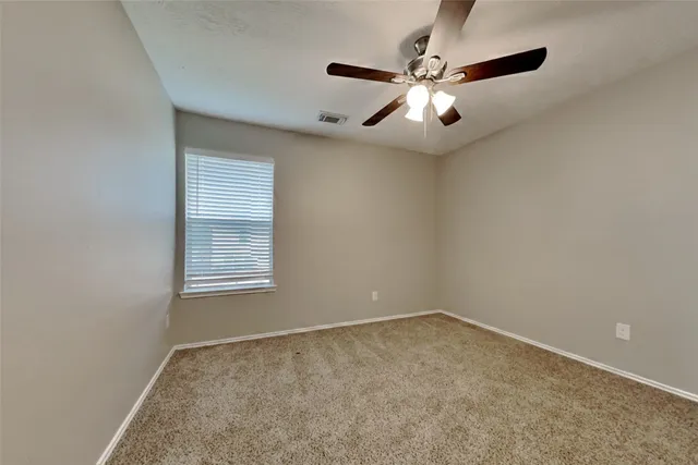 an empty room with fan and windows