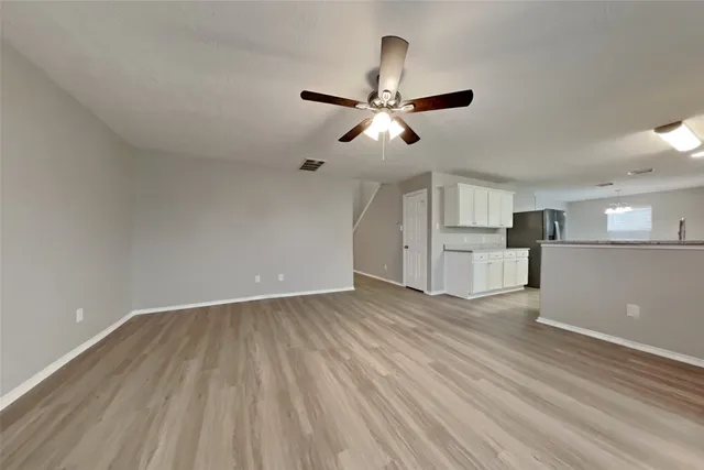a view of empty room with wooden floor and window