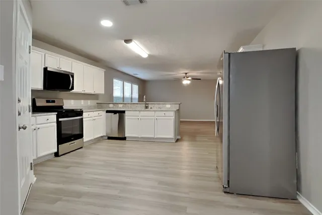 a view of kitchen with microwave oven stove and cabinets