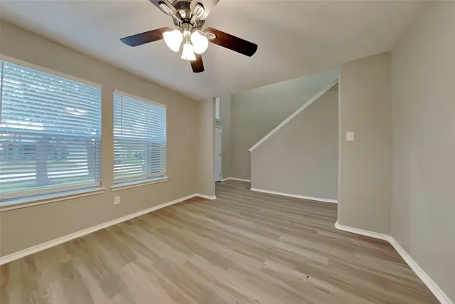 a view of an empty room with a window and wooden floor