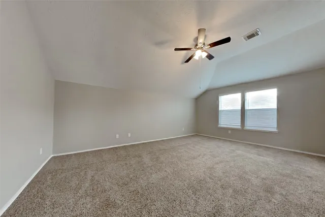 an empty room with a window and a fan