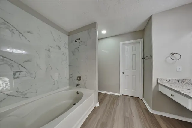 a bathroom with a tub a sink and a shower