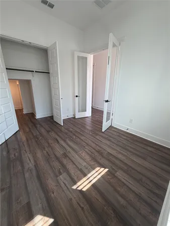 an empty room with wooden floor and closet