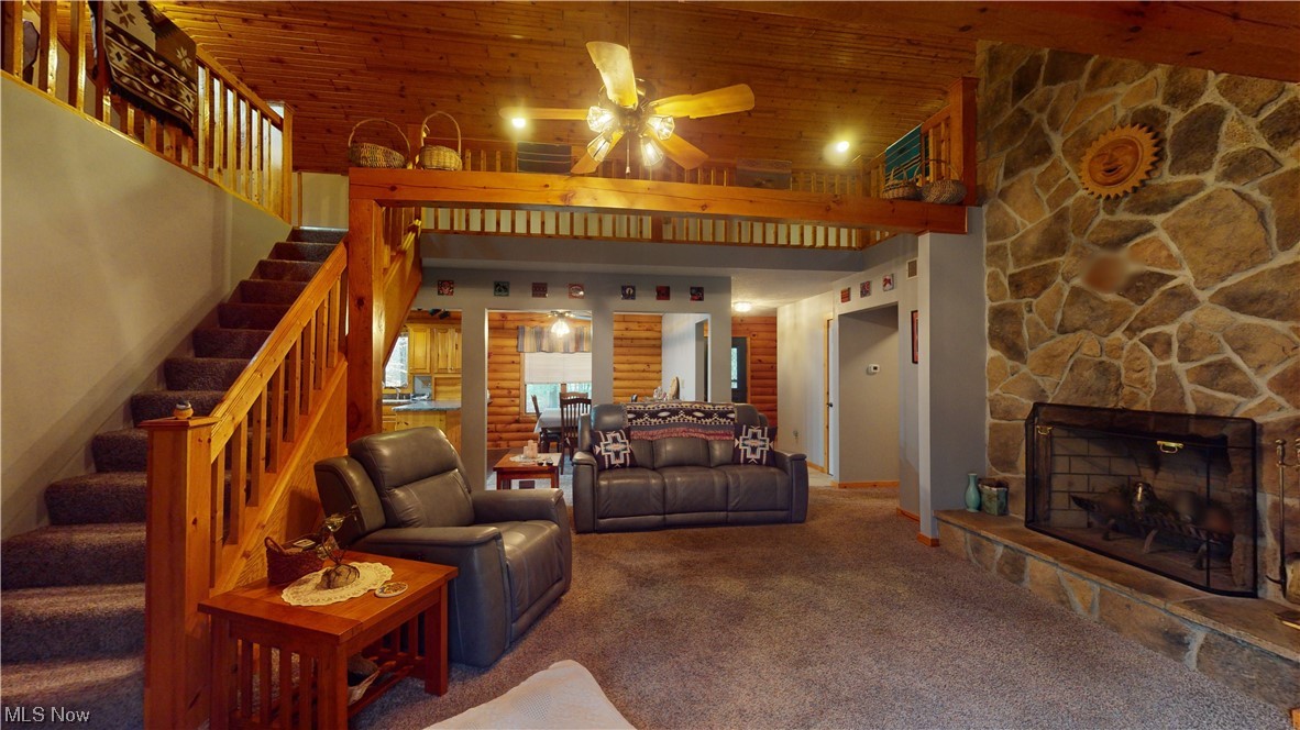 4308 Lyntz Road Warren, OH 44481 - Photo 22 of 34 Carpeted living room featuring ceiling fan, a stone fireplace, a high ceiling, and wooden ceiling