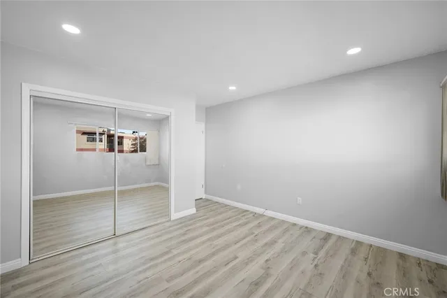 en empty room with wooden floor and window