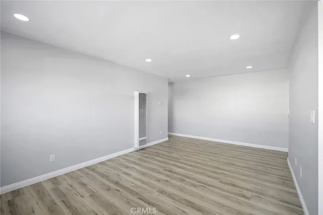 an empty room with wooden floor and white walls