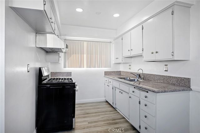 a kitchen with stainless steel appliances granite countertop a sink stove and cabinets