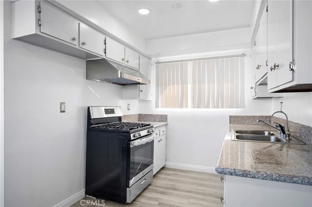 a kitchen with stainless steel appliances granite countertop a sink stove and cabinets