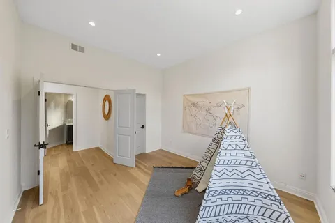 a view of a bedroom with wooden floor and windows
