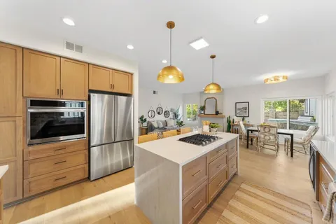 a kitchen with stainless steel appliances granite countertop a sink stove and refrigerator