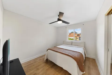 a bedroom with a bed and a painting on the wall