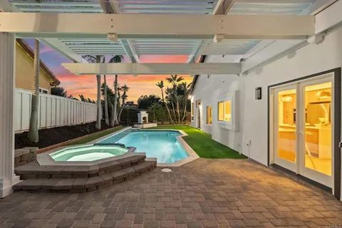 a view of a patio with a table and chairs under an umbrella