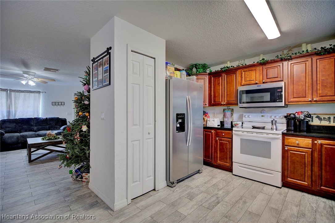 1700 Schlosser Road Sebring, FL 33870 - Photo 13 of 40 a kitchen with stainless steel appliances granite countertop a refrigerator stove microwave and sink