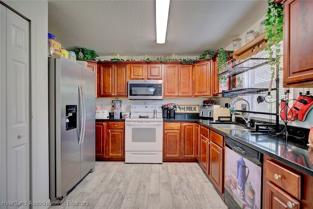 1700 Schlosser Road Sebring, FL 33870 - Photo 14 of 40 a kitchen with stainless steel appliances granite countertop a refrigerator and a stove top oven