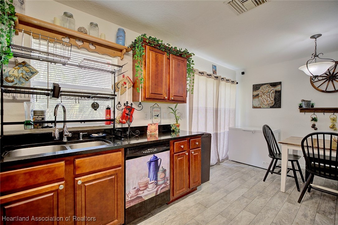 1700 Schlosser Road Sebring, FL 33870 - Photo 15 of 40 a kitchen with stainless steel appliances granite countertop a sink and cabinets
