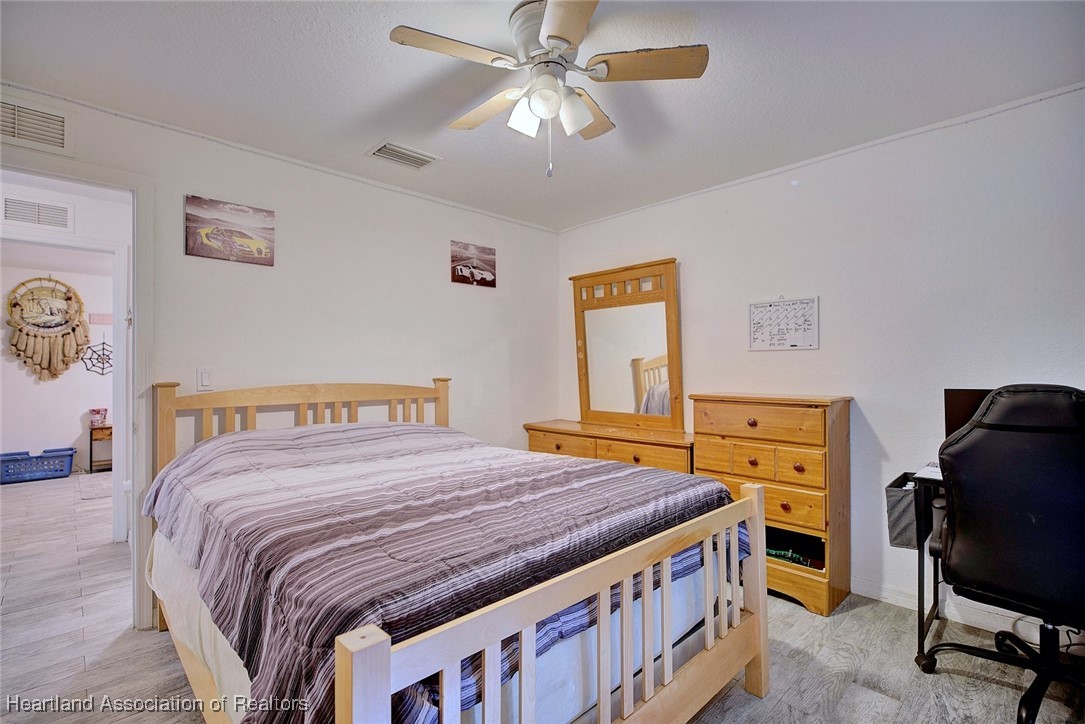 1700 Schlosser Road Sebring, FL 33870 - Photo 18 of 40 a bedroom with a bed and a chandelier