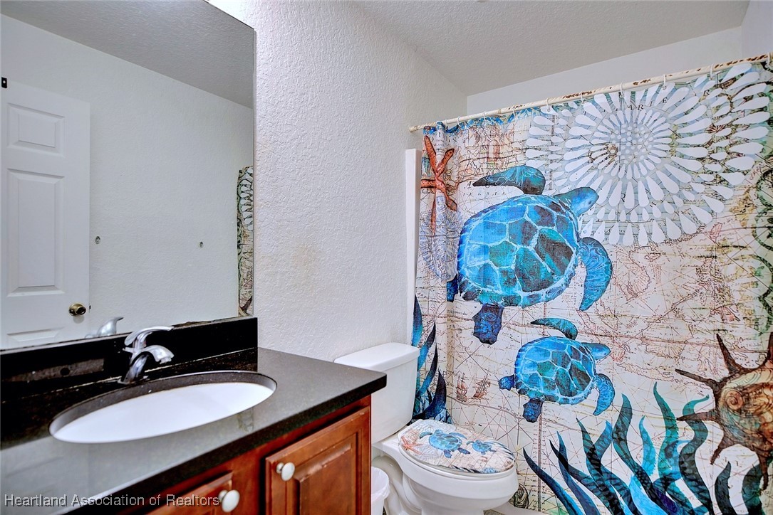 1700 Schlosser Road Sebring, FL 33870 - Photo 20 of 40 a bathroom with a sink toilet mirror and vanity