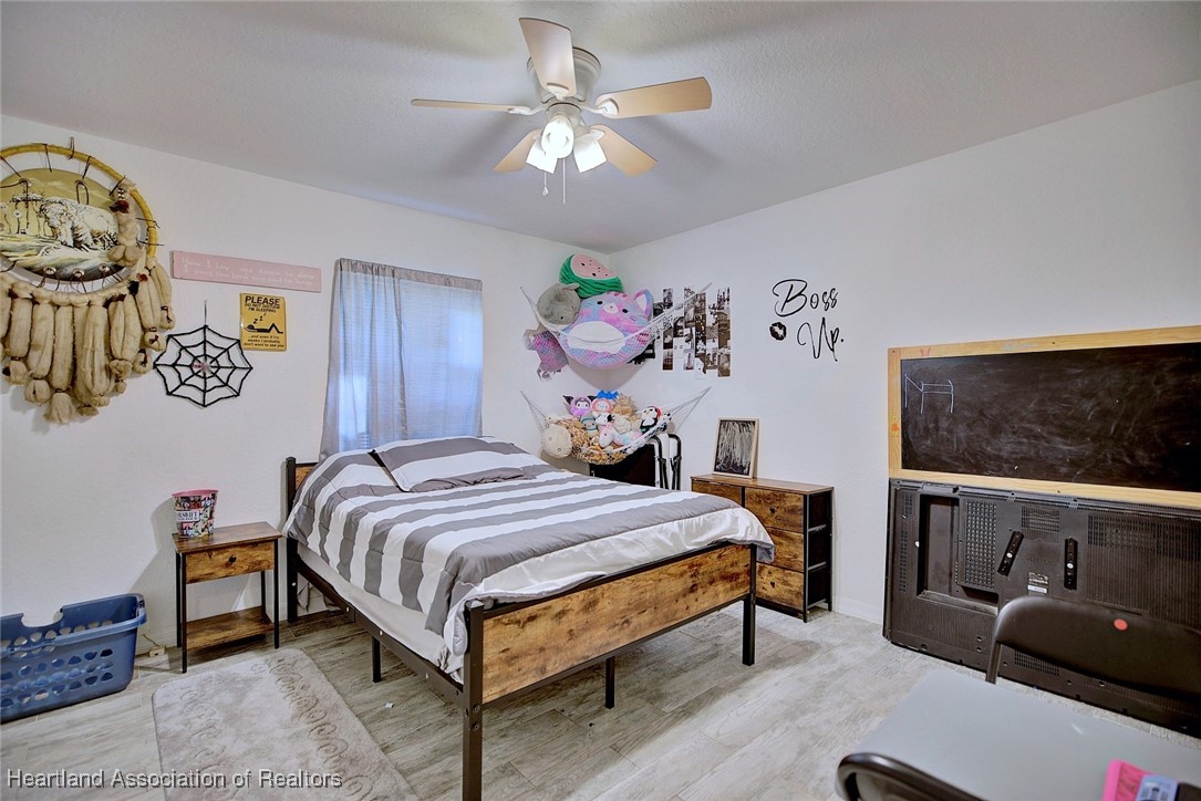 1700 Schlosser Road Sebring, FL 33870 - Photo 21 of 40 a bedroom with a bed and a flat tv screen on dresser