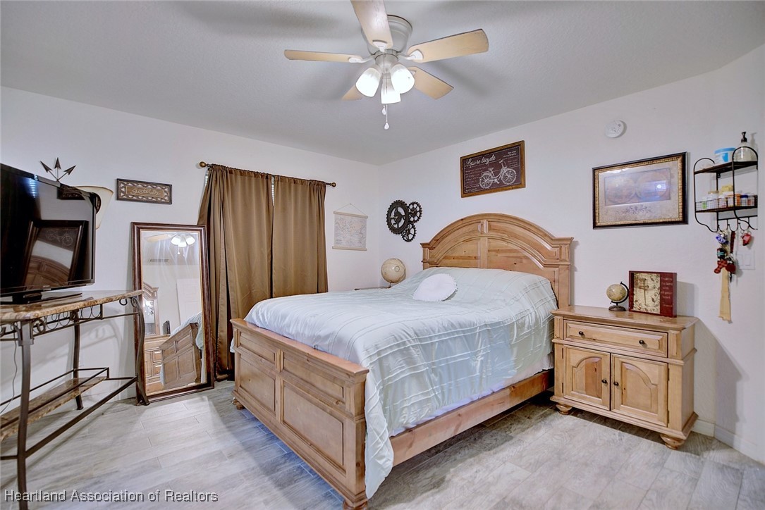 1700 Schlosser Road Sebring, FL 33870 - Photo 25 of 40 a bedroom with a bed and a flat tv screen on dresser