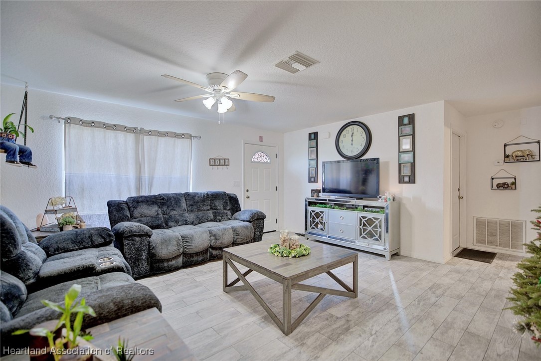 1700 Schlosser Road Sebring, FL 33870 - Photo 7 of 40 a living room with furniture a clock and a ceiling fan