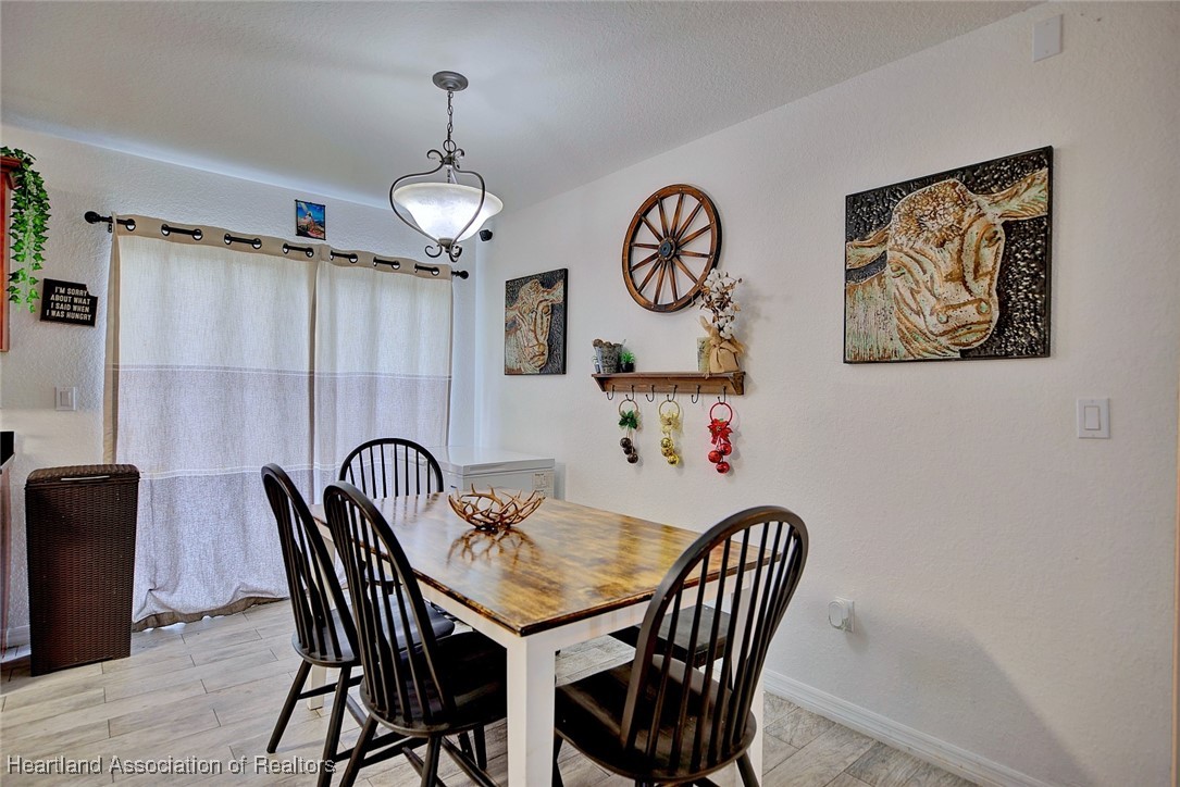 1700 Schlosser Road Sebring, FL 33870 - Photo 9 of 40 a view of a dining room with furniture wooden floor and a chandelier