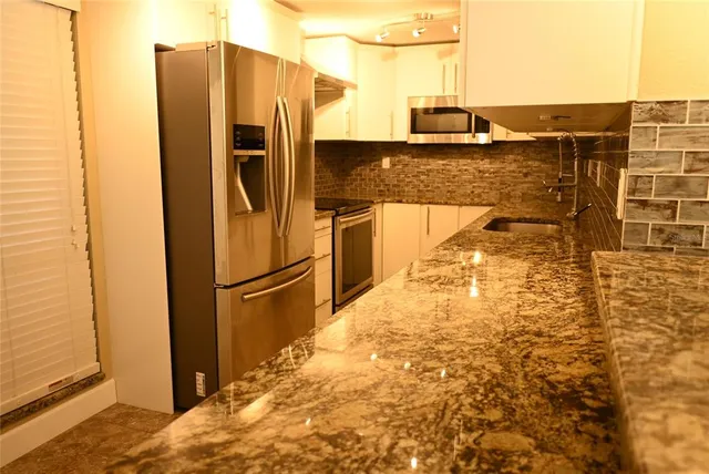 a kitchen with refrigerator and microwave