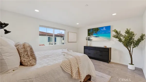 a bedroom with a large bed and a potted plant