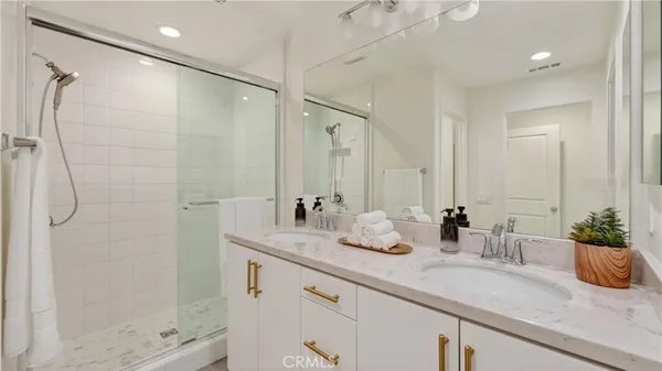 a bathroom with a shower sink and mirror