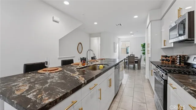 a kitchen with stainless steel appliances granite countertop a sink stove and refrigerator