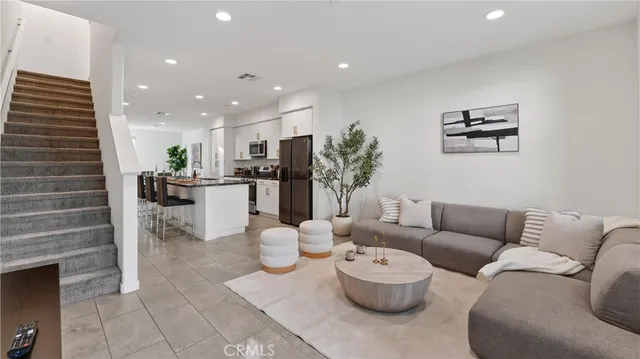 a living room with furniture and a dining table with kitchen view