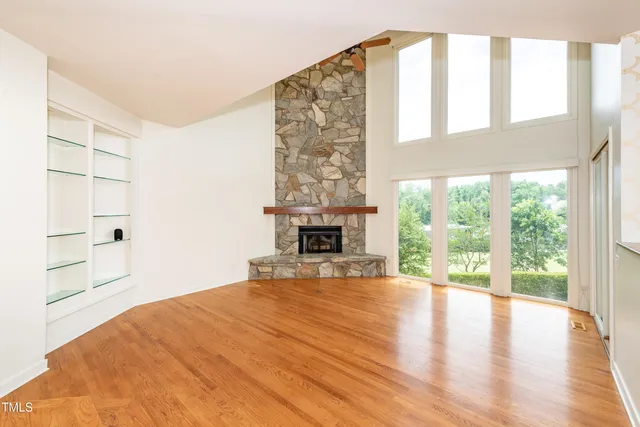 a view of empty room with wooden floor and fireplace