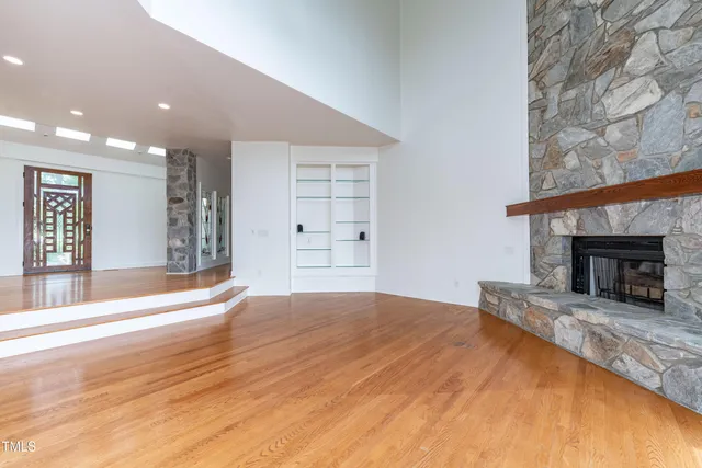 a view of empty room with wooden floor and fireplace