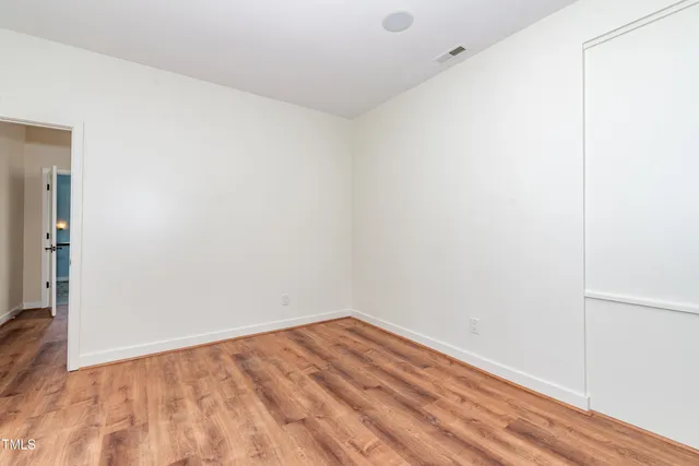 an empty room with a window and a ceiling fan