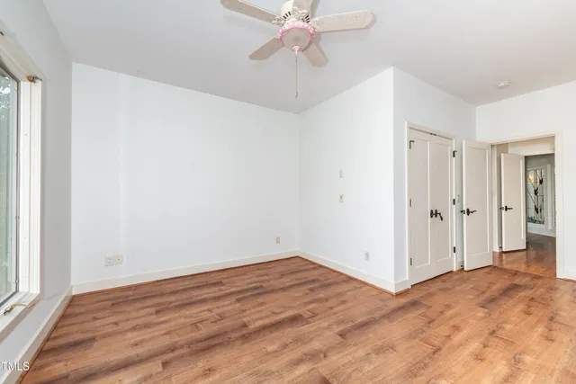 a view of empty room with wooden floor